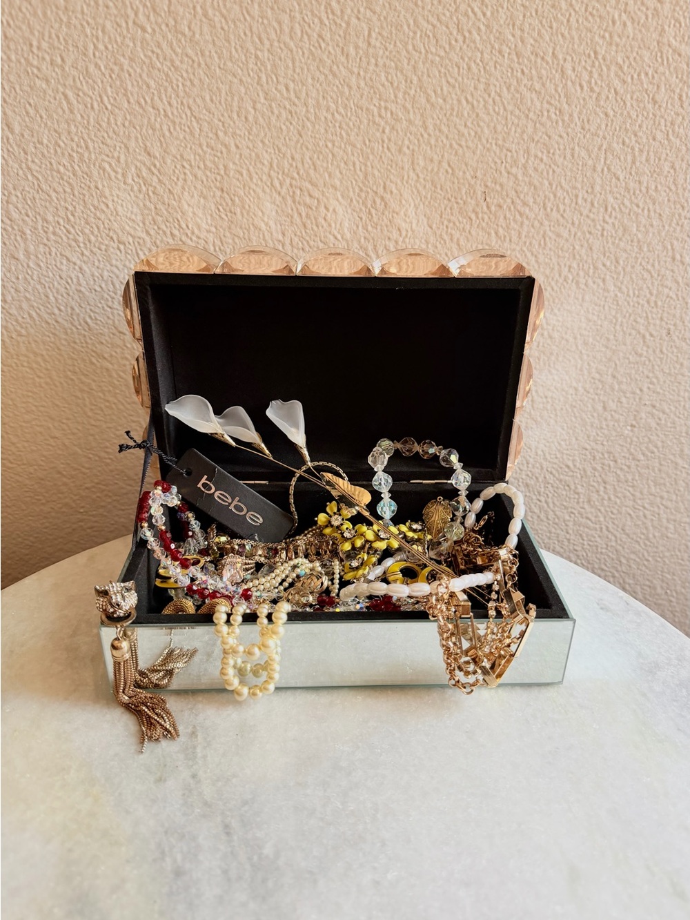bebe jewelry box with an assortment of vintage and modern gold-tone jewelry